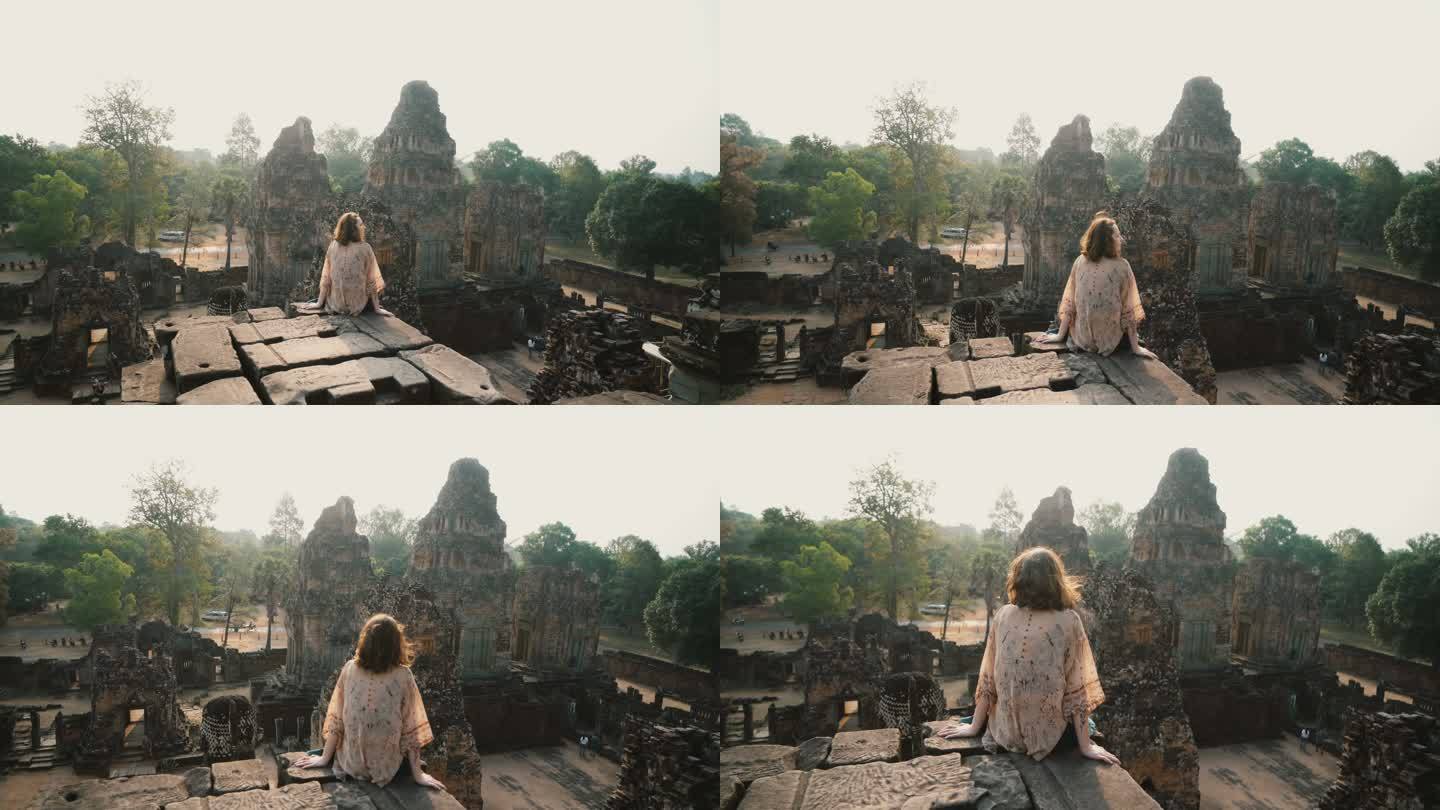 柬埔寨吴哥寺的一名妇女坐着看风景
