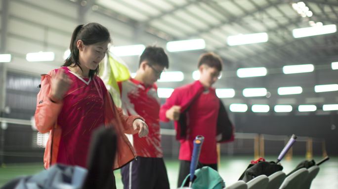 四名年轻男女运动员在羽毛球场相遇