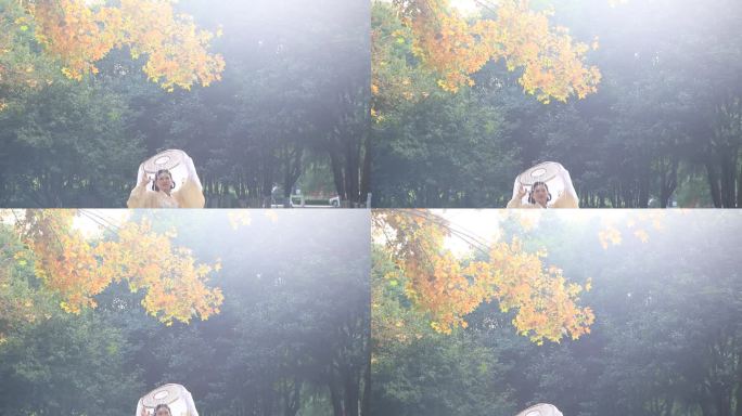 女子在公园银杏树下拍照
