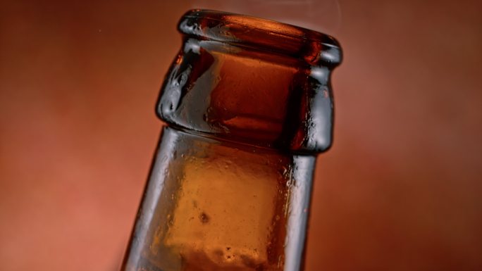 SLO MO泡沫状液体从棕色瓶子的颈部上升
