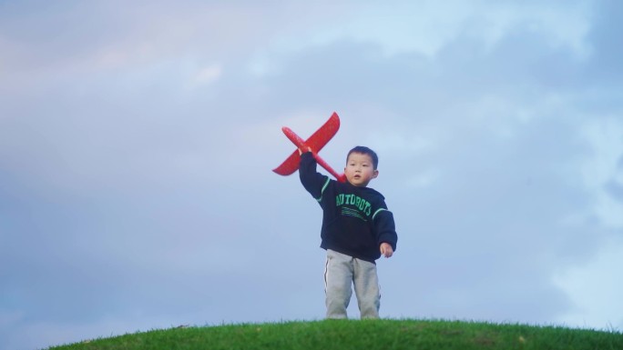 小孩草地扔飞机模型快乐时光父母陪伴儿童节