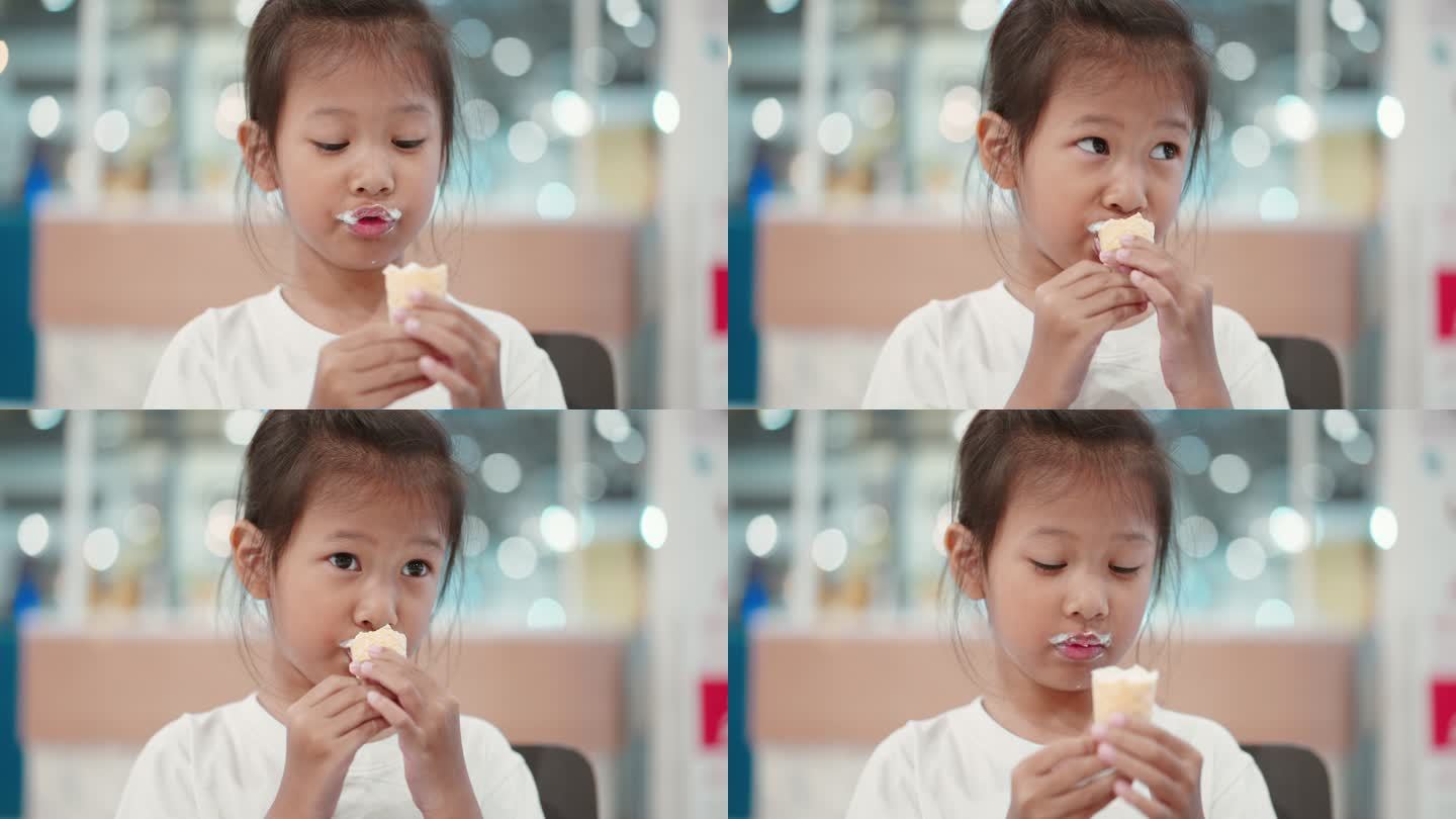亚洲小女孩在室内餐厅吃冰淇淋