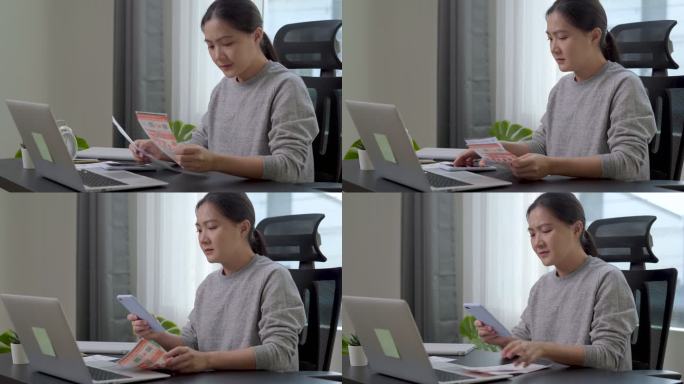 坐在家里办公室的亚洲女性担心电费支付问题。