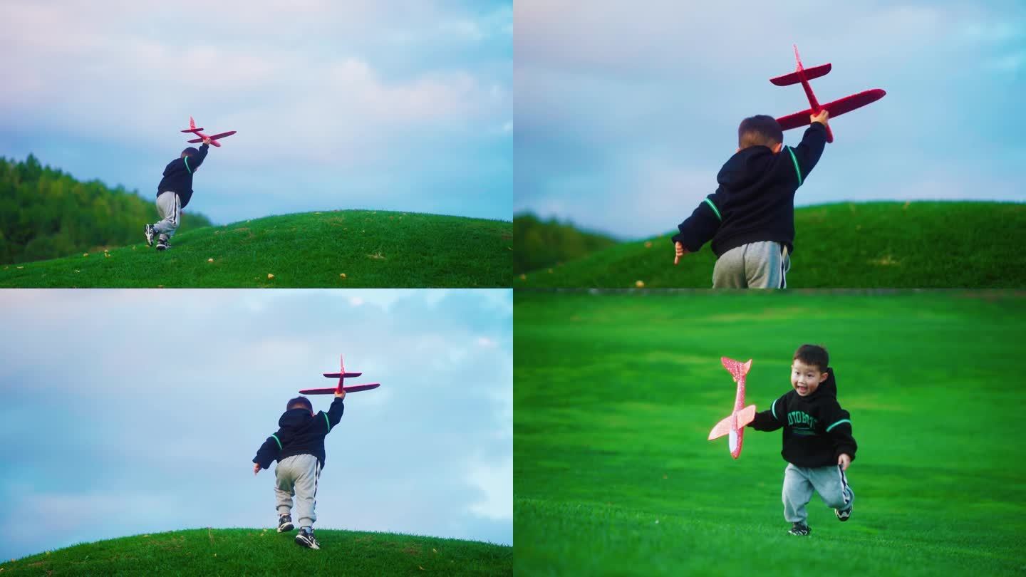 小男孩举起飞机模型草地奔跑快乐童年儿童节