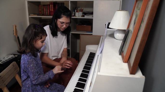 小女孩和老师在音乐学校学习钢琴