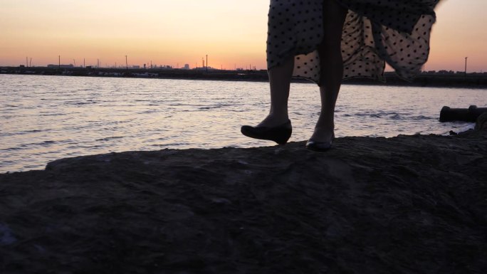 夕阳海边女人走路