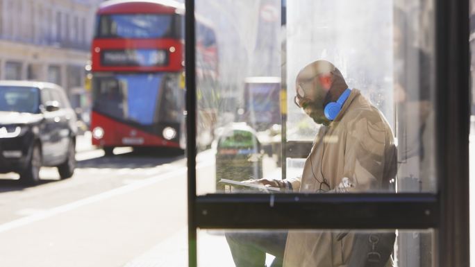 英国伦敦阳光城公交车站的男子看书