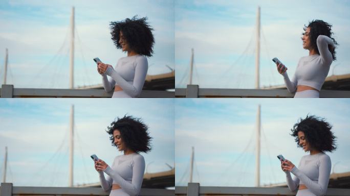 一位身穿白色慢跑服、留着黑色卷发的年轻女跑步者微笑着在电话里发短信，