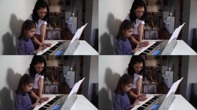 音乐家庭课。可爱的小女孩学习弹奏钢琴键盘合成器-在家学习音乐