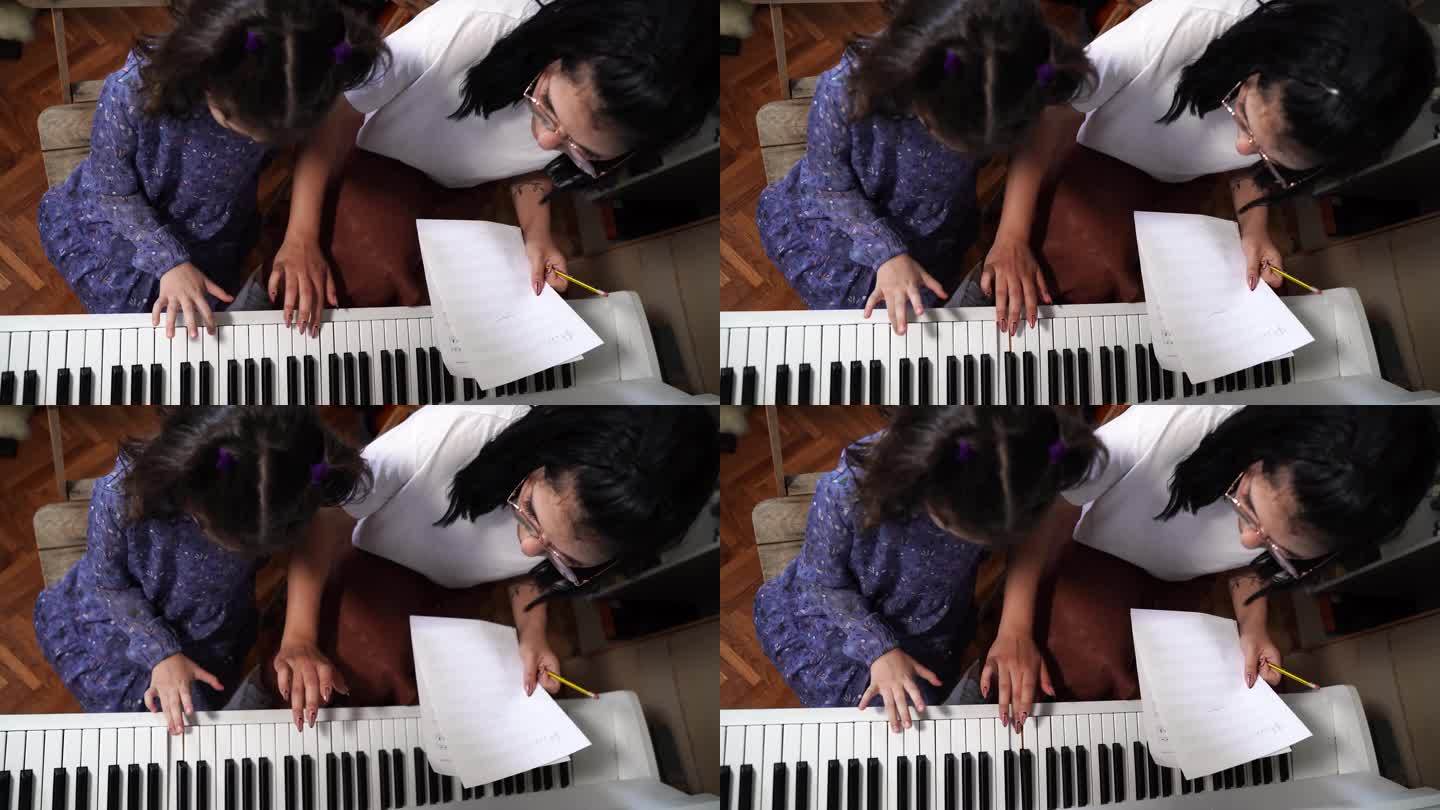 小女孩和老师在音乐学校学习钢琴