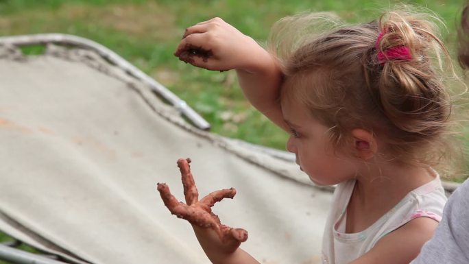 小女孩在院子里玩粘土