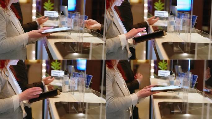 女商人在酒店前台的平板电脑上签名