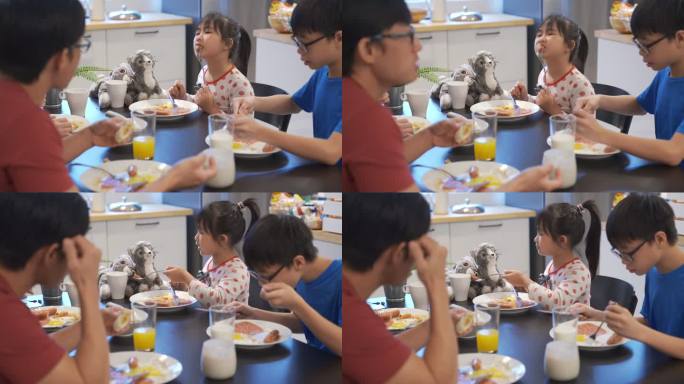 可爱的亚洲中国女孩与父母在厨房吃西式早餐
