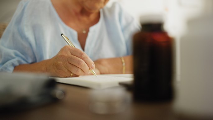 老年妇女在线咨询时做笔记