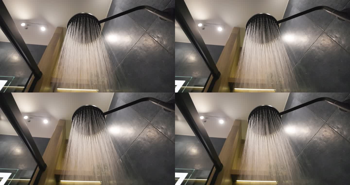 水从深蓝色现代豪华浴室的淋浴喷头流出。