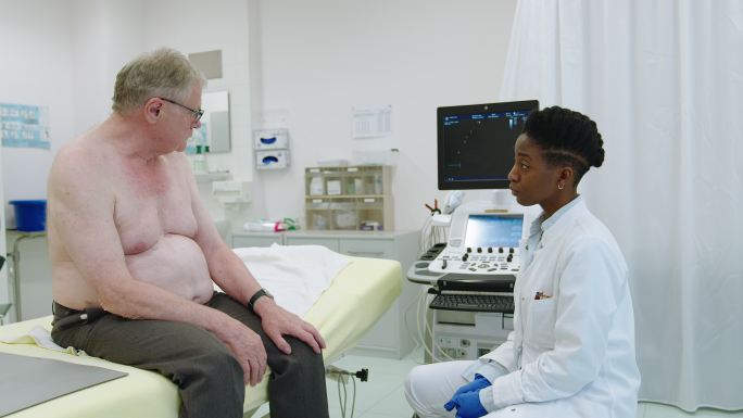 心脏病学专家在心脏病诊所与老年男性患者交谈