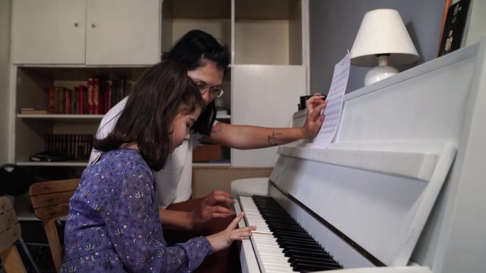 私人音乐老师给小女孩上钢琴课