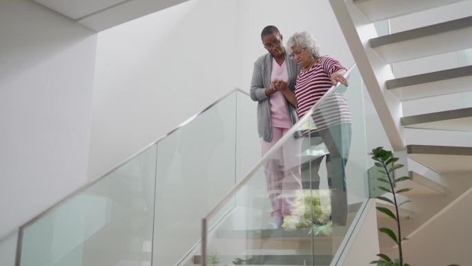护士帮助一位老年妇女走楼梯