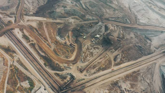 露天采石场中装载推土机的大型采矿卡车工作的部分矿坑鸟瞰图