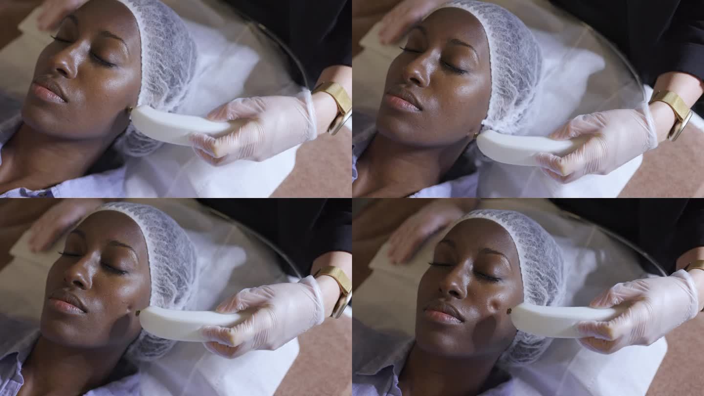 黑人放松的女人在水疗中心接受年轻面部护理
