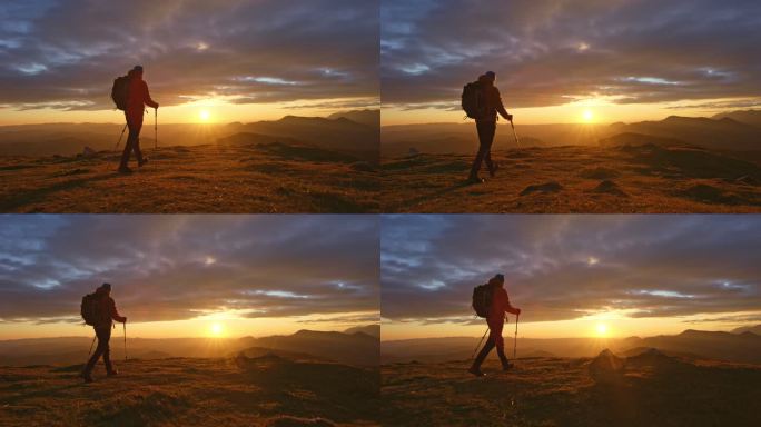 AERIAL SLO MO男性徒步旅行者在日落时到达山顶