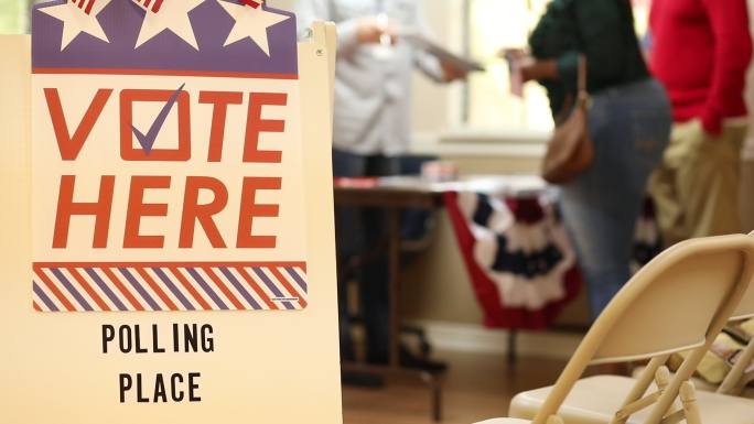 在这里投票。在美国大选中，美国民众在投票站登记投票。