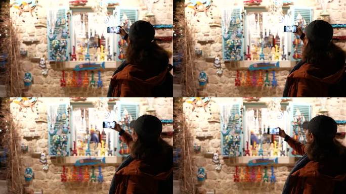 成熟的旅游女性在智能手机上拍摄纪念品商店