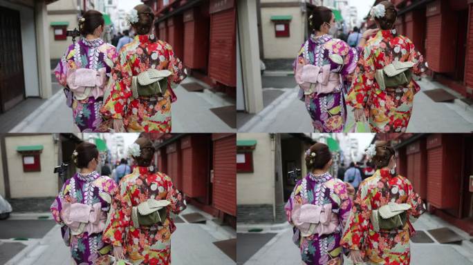 Kimono的年轻女性朋友在日本传统小镇散步的后视图