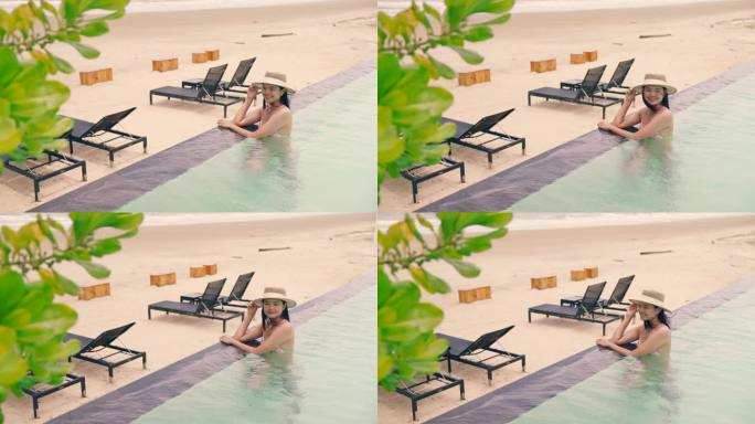 海滩上的豪华旅游女性坐在泳池边的沙滩椅上。