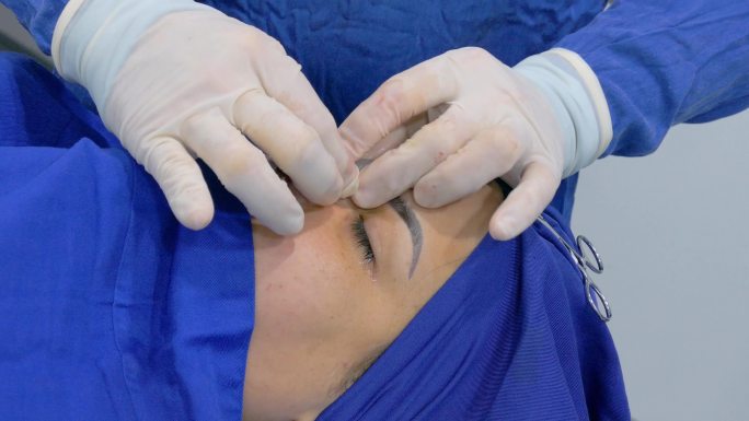 外科医生完成了鼻中隔偏曲和鼻整形手术后的女性患者。