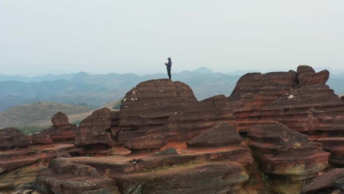 航拍男人站在贵州铜仁腊尔山红石林的山顶上
