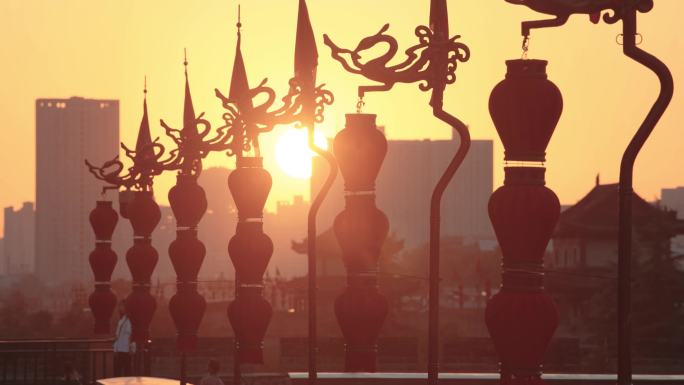 日落时分古城墙顶端的龙旗和灯笼/西安，中国陕西