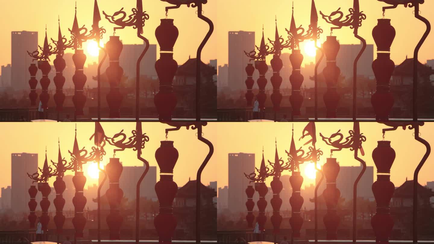 日落时分古城墙顶端的龙旗和灯笼/西安，中国陕西