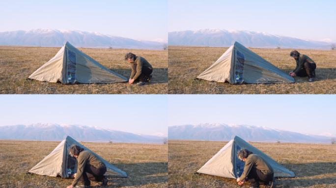 在日落时搭帐篷，在大自然中露营。