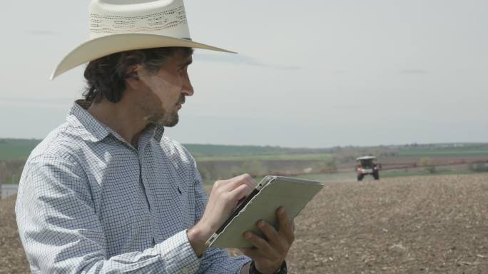 农民使用数字平板电脑操作作物喷雾器。