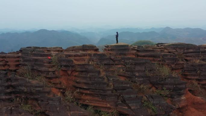 航拍男人站在贵州铜仁腊尔山红石林的山顶上