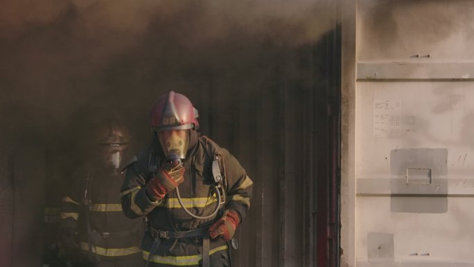在这种情况下，消防队员从火灾的烟雾中逃生。