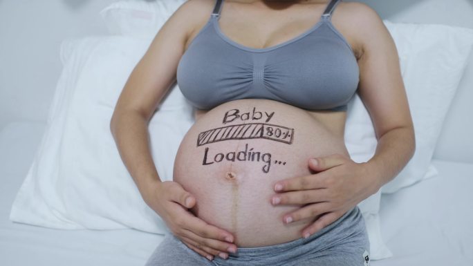 快乐的亚洲孕妇，腹部涂有负重概念