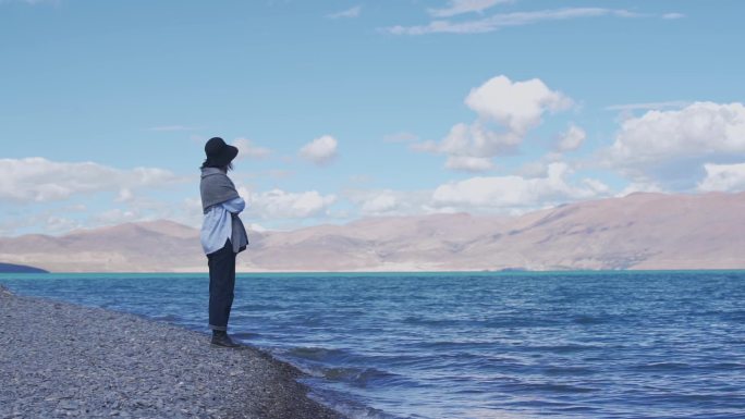 女人站在西藏佩枯错湖岸边
