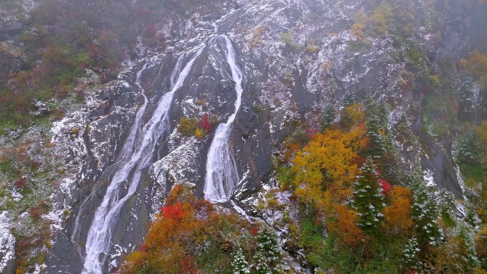 航拍秋冬时节雪后的瀑布和红叶