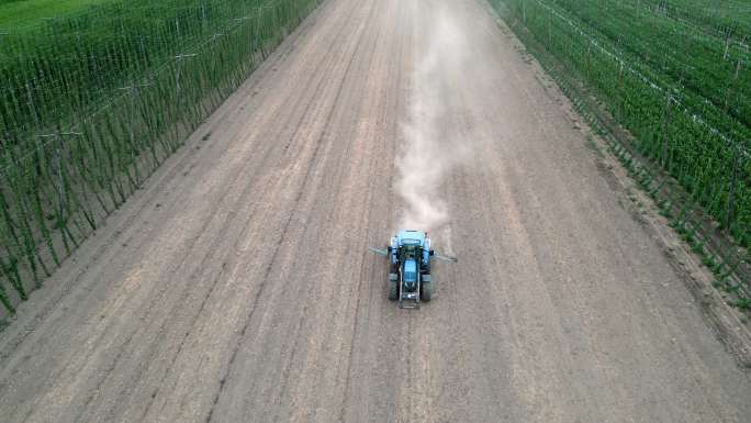 拖拉机在干燥的土地上播种，留下尘云的鸟瞰图