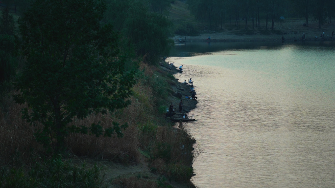 傍晚人们在河边钓鱼