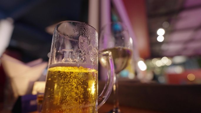 酒吧桌上的啤酒杯冒泡的啤酒起泡酒气泡酒