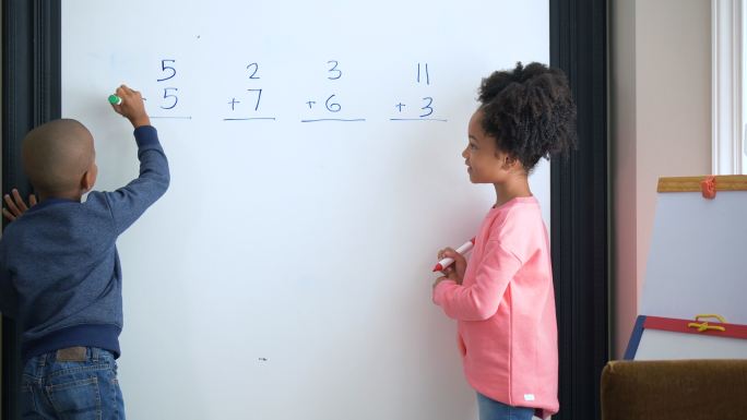 两个非洲裔美国孩子在白板上做数学