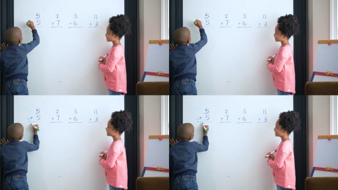 两个非洲裔美国孩子在白板上做数学