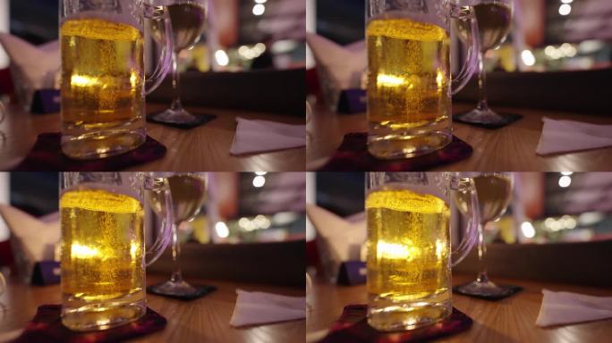 酒吧桌上的啤酒杯冒泡的啤酒气泡酒