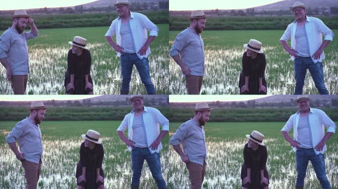夕阳下稻田里可爱的女农民和两个男农民微笑