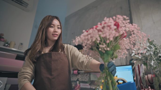 亚洲华人女花商，小企业主，在花店布置花束。经营小企业的日常生活