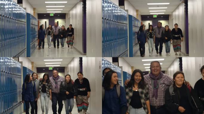五名高中或中学生与一名成年男教师或辅导员一起在大厅里散步