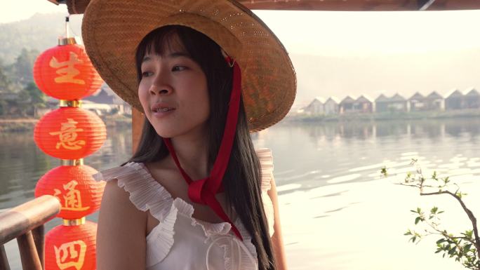 亚洲女子在村里的河上划船